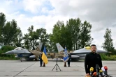 Le président ukrainien Volodymyr Zelensky devant deux chasseurs F-16 lors d'une cérémonie dans un lieu tenu secret en Ukraine, le 4 août 2024 