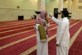 Un bénévole vérifie la température d'un fidèle dans une mosquée à La Mecque, en Arabie saoudite, le 21 juin 2020