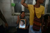 Des proches d'un manifestant tué en protestant contre le coup d'Etat en Birmanie saluent avec trois doigts levés, signe de résistance, devant la morgue où ils attendent le corps de leur proche, à l'hôpital Thingangyun de Rangoun le 15 mars 2021