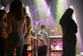Un serveur avec un masque sert des clients dans un night-club à Wuhan, le 20 janvier 2021