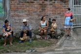 Des habitants tiennent des poules distribuées par des employés municipaux à des familles dans le besoin, à Sunapa (Salvador), le 2 juillet 2020