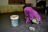 Hajira Bibi nettoie la boue dans sa maison endommagée par la crue d'une rivière dans le village de Jindi, dans le district de Charsadda,  dans le nord-ouest du Pakistan, le 1er septembre 2022