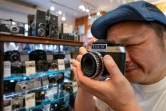 Yoshinobu Ishikawa, patron de Popeye Camera, un magasin spécialisé dans la photographie argentique, teste un appareil photo d'occasion à vendre, le 9 juillet 2024 à Tokyo