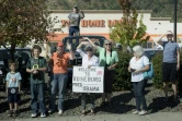 Des habitants le long de la route regardent passer la voiture du président Barack Obama, le 9 octobre 2015 à Roseburg