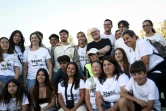Le prêtre et DJ Guilherme Peixoto avec des fans pour une photo de groupe avant de se produire sur scène lors d'une fête populaire à Coimbra, le 3 juillet 2024 au Portugal