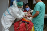 Un personnel de santé effectue un prélèvement sur une enfant dans un centre de test, le 19 août 2020 à Hyderabad, en Inde
