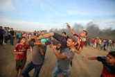 Des secouristes palestiniens portent un manifestant blessé près de la frontière entre la bande de Gaza et Israël, le 5 octobre 2018