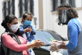 Une femme et sa fille se lavent les mains avant de recevoir un repas à Guatemala City le 16 avril 2020.
