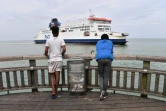 Des migrants venant d'Erythrée regardent un ferry arrivant de Grande-Bretagne accoster au port de Calais, le 12 août 2019