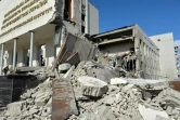Des secouristes dans les décombres d'un immeuble administratif bombardé à Kharkiv en Ukraine, le 18 mars 2022