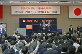 Le président de Hon Hai Precision, connu aussi sous le nom de Foxconn, Terry Guo (C) et le vice-président Tai Jeng-wu (G) posent avec le président de Sharp Kozo Takahashi, lors d'une conférence de presse à Osaka le 2 avril 2016