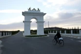 Un membre de l'OMPI (Organisation des moudjahidines du peuple d'Iran) à bicyclette entre dans la cité d'Ashraf 3 près de Tirana, le 4 mars 2020