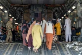 Des Afghans montent à bord d'un avion de l'US Air Force, le 20 août 2021 à l'aéroport de Kaboul