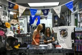 Une employée du magasin "Space Shirts" dédié à l'espace, et Brenda Mulberry sa fondatrice (à droite), près de Cap Canaveral en Floride le 27 août 2022