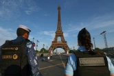 Un membre d'une force de sécurité qatarie (gauche) et une gendarme française se tiennent près de la tour Eiffel, le 18 juillet 2024 à Paris