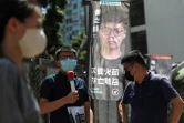 Le militant pro-démocratie Joshua Wong (C), candidat pour les primaires organisées par son camp, durant le scrutin à Hong Kong le 11 juillet 2020