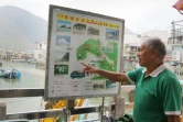 Wong Yung-kan, conducteur d'un bateau de tourisme, montre sur un plan le lieu où se trouvent les dauphins roses, à Tai O, à Hong Kong, le 4 novembre 2015