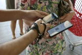 Une employée d'un centre commercial vérifie le pass sanitaire d'une cliente à Ajaccio, en Corse, le 16 août 2021