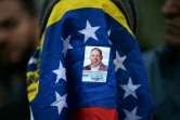 Une femme le visage couvert du drapeau du Veeéuzela et d'un autocollant du candidat de l'opposition Edmundo Gonzalez Urrutia lors d'une veillée pour la libération des prisonnies politiques arrêtés après la présidentielle, à Caracas, le 8 août 2024