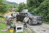 Un couple tente de sauver des meubles pendant des inondations à Jackson, le 28 juillet 2022 dans le Kentucky