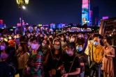 Des passagers portant des masques pour éviter de propager le coronavirus attendent d'embarquer dans un bateau pour regarder un spectacle, à Wuhan le 27 septembre 2020 