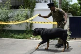 Un policier sri-lankais et son chien inspectent le 23 avril 2019 une zone autour de la maison de l'un des suspects dans les attentats suicide à Colombo