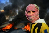 Un manifestant irakien bloque une route dans la ville irakienne de Najaf (sud), le 27 novembre 2019