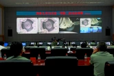 Sur cette image d'archive du 24 juin 2012, des techniciens chinois du Centre spatial de Jiuquan  suivent l'arrimage du vaisseau Shenzhou-9  à la station spatiale Tiangong-1.     