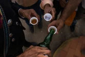 Des vénézuéliens boivent une boisson locale à base d'agave le cocuy lors d'une fête religieuse à Bobaré, le 12 décembre 2019