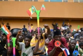 Un participant à un concert de soutien aux militaires brandit des drapeaux du Niger, du Burkina Faso et du Mali, le 13 août 2023 à Niamey