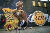 Un fan allume une bougie devant une fresque représentant Kobe Bryant, le 26 janvier 2020 à Los Angeles 