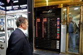 Un homme regarde un panneau affichant les taux de change des devises étrangères. Le rial iranien a perdu une grande partie de sa valeur depuis le rétablissement des sanctions américaines contre l'Iran. Photo du 3 novembre 2018 à Téhéran
