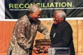 Le président sud-africain Nelson Mandela (g) reçoit cinq volumes de la Commission vérité et réconciliation des mains de son président Desmond Tutu, à Pretoria, le 29 octobree 1998