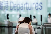 Des habitants disent adieu à leurs proches avant de prendre un vol pour Londres à l'aéroport de Hong Kong le 17 juillet 2021