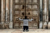 Un Chrétien prie devant les portes fermées du Saint-Sépulcre, à Jérusalem, le 9 avril 2020