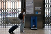 Une voyageuse lit des informations sur la circulation des transports en commun à la station de métro Victoria, le 19 août 2022 à Londres lors d'une grève pour les salaires