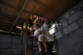 Myrna Albos, avec son enfant dans sa bicoque, dans un bidonville à la périphérie de Manille, le 10 octobre 2017
