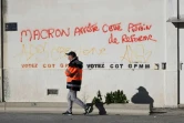 Un docker passe devant un slogan contre la réforme des retraites, lords du blocage du port autonome de Marseille, le 12 décembre 2019