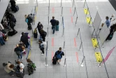 Des passagers masqués font la queue pour s'enregistrer, le 2 juillet 2021 à l'aéroport de Düsseldorf, en Allemagne