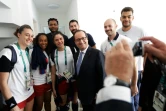 Le président français François Hollande pose en compagnie de membres des équipes françaises de hand-ball masculine et féminine lors d'une visite du village olympique à Rio de Janeiro, le 4 août 2016
