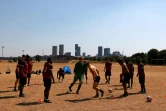 Des hommes s'entraînent au football sur une pelouse désséchée à Londres, le 13 août 2022