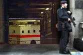 Un policier monte la garde pendant qu'un fourgon, transportant l'imam radical Abdullah al-Faisal, arrive dans un tribunal londonien, le 7 mars 2003 