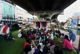 Des dizaines d'enfants assistent aux activités après l'école organisées par une bibliothèque de rue installée sous une voie rapide, le 10 février 2019 à Jakarta, en Indonésie