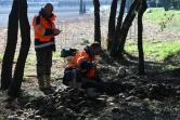Deux archéologues fouillent le sol d'un terrain millitaire à la recherche de sépultures d'enfants harkis, le 28 février 2022 à Laudun-l'Ardoise, dans le Gard