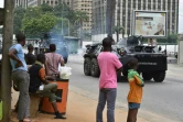 Des ivoiriens regardent passer une patrouille de gendarmes près du quartier général de l'armée, le camp militaire de Gallieni, à Abidjan le 12 mai 2017 