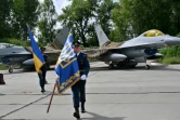 Des militaires ukrainiens passent devant chasseurs F-16 après une cérémonie dans un lieu tenu secret en Ukraine, le 4 août 2024 