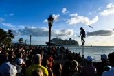 Une foule de touristes observe un artiste de rue, un bateau de croisière au large, le 11 avril 2022 à Key West, en Floride