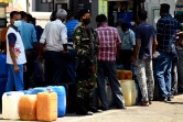 Un soldat monte la garde pendant que des habitants font la queue à une station-services, le 29 mars 20222 à Colombo, au Sri Lanka