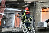 Des pompiers tentent d'éteindre un incendie dans un immeuble d'habitation après des frappes dans le centre de la ville ukrainienne de Kharkiv, le 17 avril 2022 
