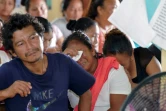 Des proches des victimes de l'incendie d'un dortoir scolaire pendant une réunion avec le président Irfaan Ali, le 22 mai 2023 à Mahdia, au Guyana